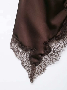 Detail of dark brown satin fabric with intricate floral eyelash lace trim and silk texture