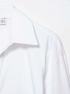 Detailed view of the white long sleeve shirt collar and the size label showing M