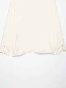 Detailed close-up of pearl white satin shirt cuffs with delicate buttons and hem finish