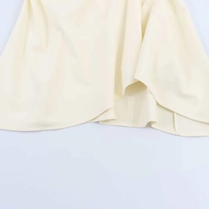 Detail shot of pleated hemline with fine stitching on light beige strapless top