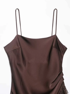 Detail of dark brown satin dress featuring delicate lace trim and thin shoulder straps