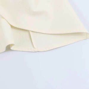 Close-up of the pleated cream fabric hem with fine stitching on a summer tube top