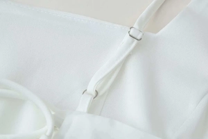 Detail of adjustable white dress strap with a square silver metal buckle for custom fit