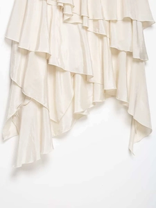 Close-up of cream ruffled skirt hem featuring elegant layered satin silk fabric texture