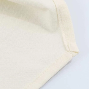 Detailed close-up of ivory ruched fabric texture with precise single-needle edge stitching