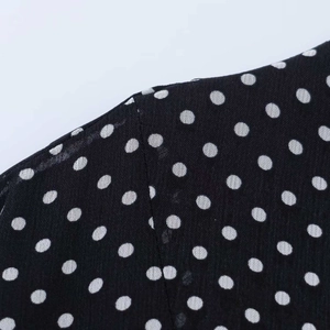 Nahaufnahme von schwarzem Polka-Dot-Stoff mit hochwertiger Naht und Verarbeitung