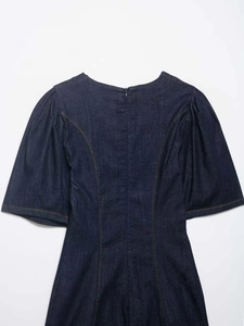 Detail of dark blue denim dress back featuring yellow contrast stitching and hidden zipper