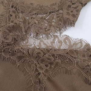 Détail du tissu en satin marron avec bordure en dentelle florale et coutures raffinées