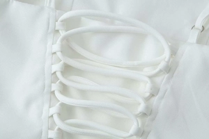 Detailed view of the white summer dress featuring back lace-up drawstring closure