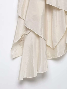 Detailed view of champagne satin skirt featuring layered irregular ruffle cascading hem