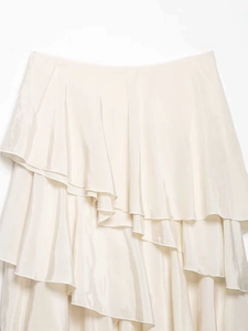 Detail of ivory tiered ruffle skirt featuring layered asymmetric hem and silky texture