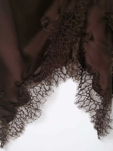 Close-up of deep brown satin dress showing intricate lace拼接 and eyelash trim detail