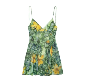 Detail of tropical floral print on a summer V-neck cami dress with green and yellow motifs