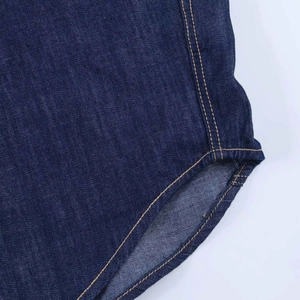Gros plan détaillé de l'ourlet en denim bleu foncé avec coutures jaunes contrastées