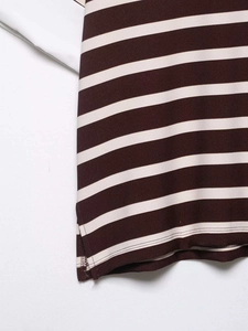 Close-up of burgundy striped knit polo hem featuring a side slit and neat stitching