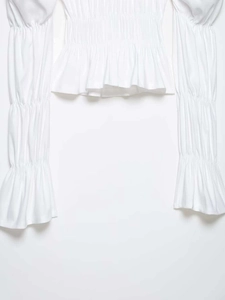 Detail of white shirred blouse with elegant elastic pleats and flared ruffle sleeves