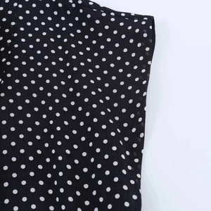 Detailaufnahme von schwarz-weißem Polka-Dot-Chiffon mit Fokus auf Stoffstruktur und Nähten