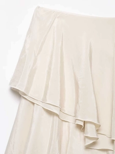 Detailed macro view of the ruffled silk layers on an asymmetrical cream satin skirt
