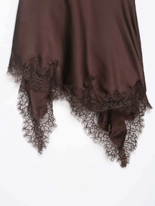 Close-up of deep brown satin dress featuring delicate eyelash lace and asymmetric hem
