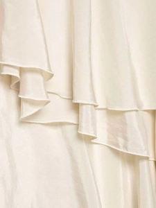 Detailed close-up of smooth ivory satin fabric with layered ruffle design details