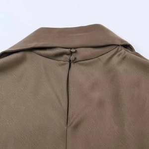 Vue détaillée de la fermeture arrière avec boutons sur une robe élégante en satin brun