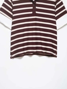 Detailed view of striped polo shirt with white contrast sleeve and ribbed collar texture