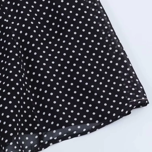 Makroaufnahme von schwarzem Chiffonstoff mit weißen Punkten und feiner Saumverarbeitung