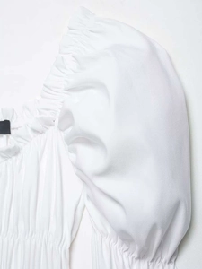Detailed macro view of white puff sleeves and ruched neckline texture on summer blouse