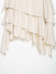 Detailed close-up of champagne satin skirt hem with elegant tiered ruffle layers