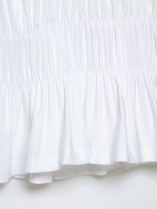 Close-up of elastic smocking detail and shirred texture on a white summer blouse
