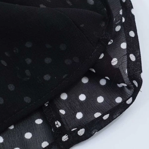 Detail der weißen Polka-Dots auf schwarzem Chiffonstoff mit feiner Doppelnahtverarbeitung