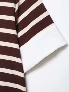 Close-up of knit striped polo sleeve with contrast white wide cuff detail