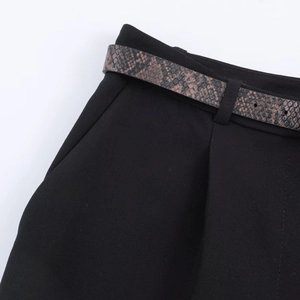 Detail of high waisted black casual shorts featuring a brown snakeskin pattern belt with buckle