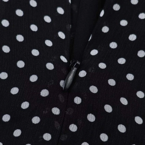 Nahaufnahme von schwarzem Polka-Dot-Chiffonstoff mit verdecktem Reißverschluss