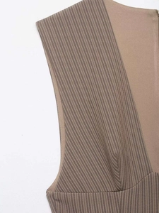 Dettaglio macro delle cuciture a righe e del design bicolore su un abito senza maniche