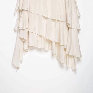 Minimalist cream tiered ruffle skirt with irregular satin texture and flowing layers