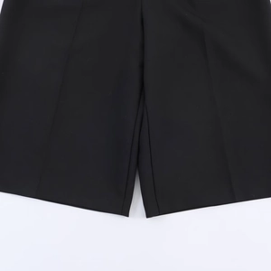Detailed close-up showing the precise crotch stitching and woven fabric of black casual shorts