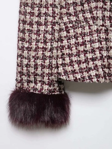 Detailed view of houndstooth tweed jacket cuff with burgundy faux fur trim details