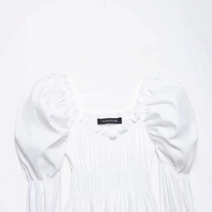 Women's white puff sleeve blouse with smocked bodice and elegant square neckline detail