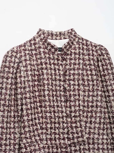 Detailed close-up of a red and white houndstooth tweed jacket with textured fabric finish