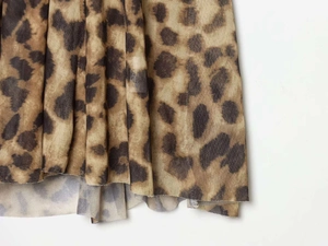 Macro detail of leopard print mesh fabric with translucent pleated texture for dresses