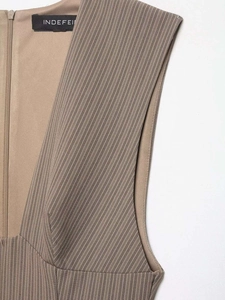 Dettaglio dello scollo a V e della zip laterale su un abito estivo a righe beige