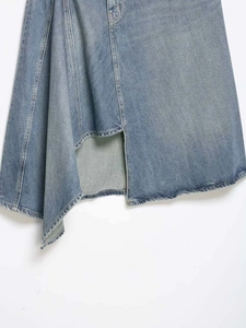 Close-up of light blue asymmetric denim skirt showing texture and stitching details