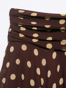 Detailed close-up of brown polka dot skirt with elegant pleated waist and chiffon fabric