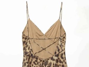 Detail of leopard print summer dress featuring an open back with lace-up cross straps