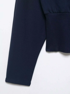 Detailed macro shot showing ribbed cuff and smooth navy blue cotton knit fabric texture