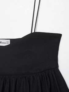 Detail view of black strappy top neckline with fine pleats and internal size label