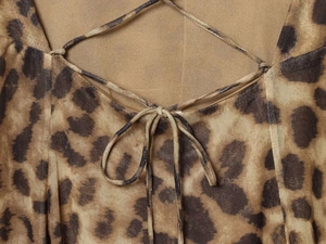 Detail of leopard print mesh dress featuring lace-up criss-cross ties and sheer fabric