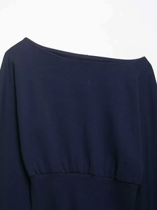 Detail view of navy blue off-shoulder sweatshirt with ribbed hem and fine cotton texture