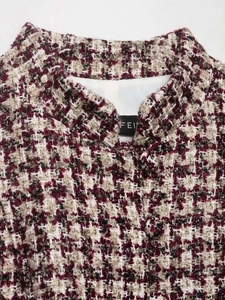Close-up of wine red houndstooth tweed jacket fabric texture and neck label detail